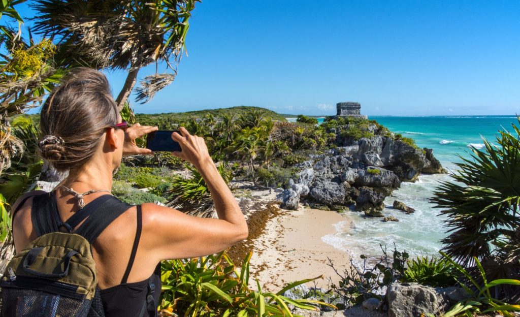 Mujer viajera, tomando fotos a las ruinas mayas de Tulum
