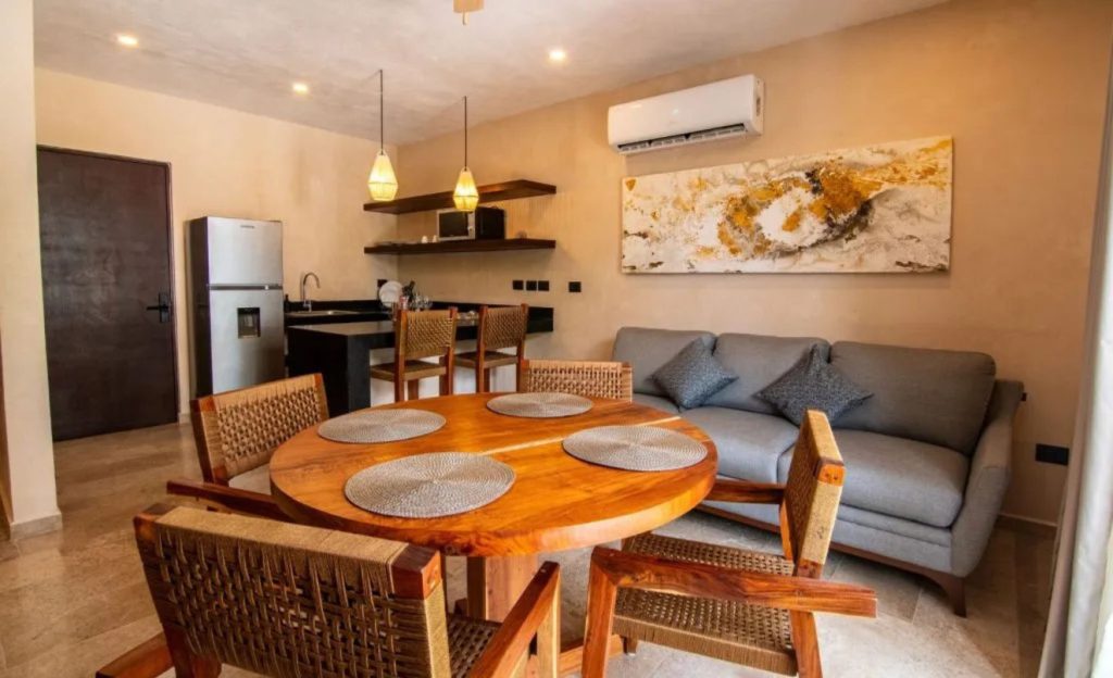 Hotel room with a living area, kitchenette, and minimalist wooden decor