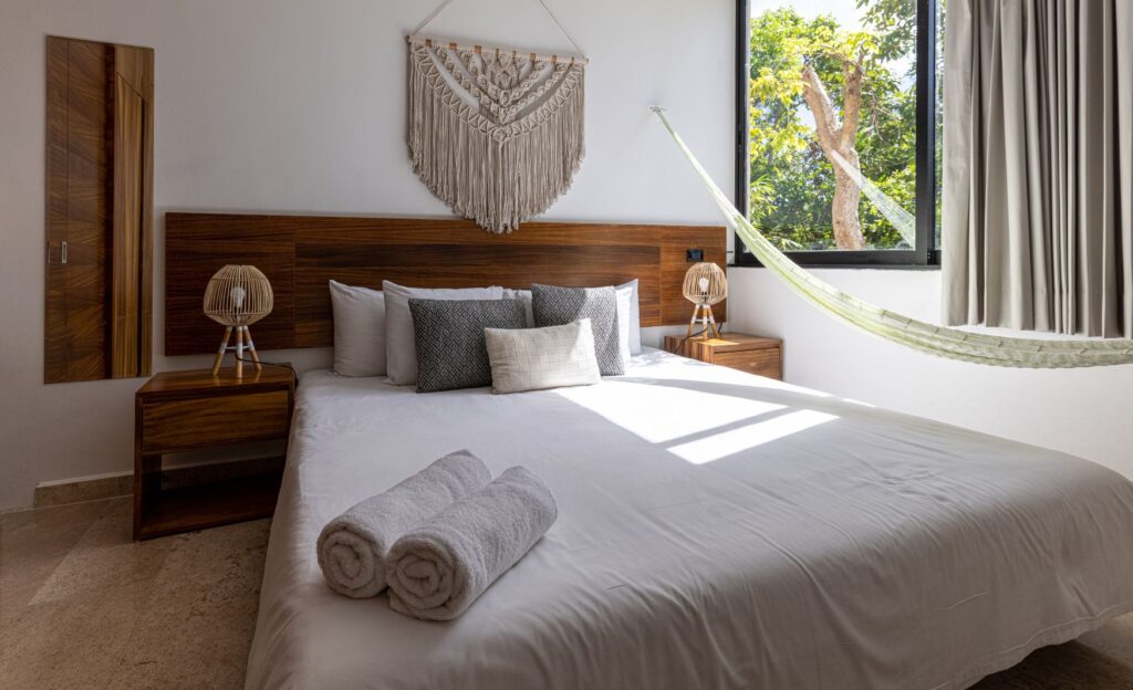 Stylish room with white, gray, and brown tones, wooden accents, a hammock, and plenty of natural light