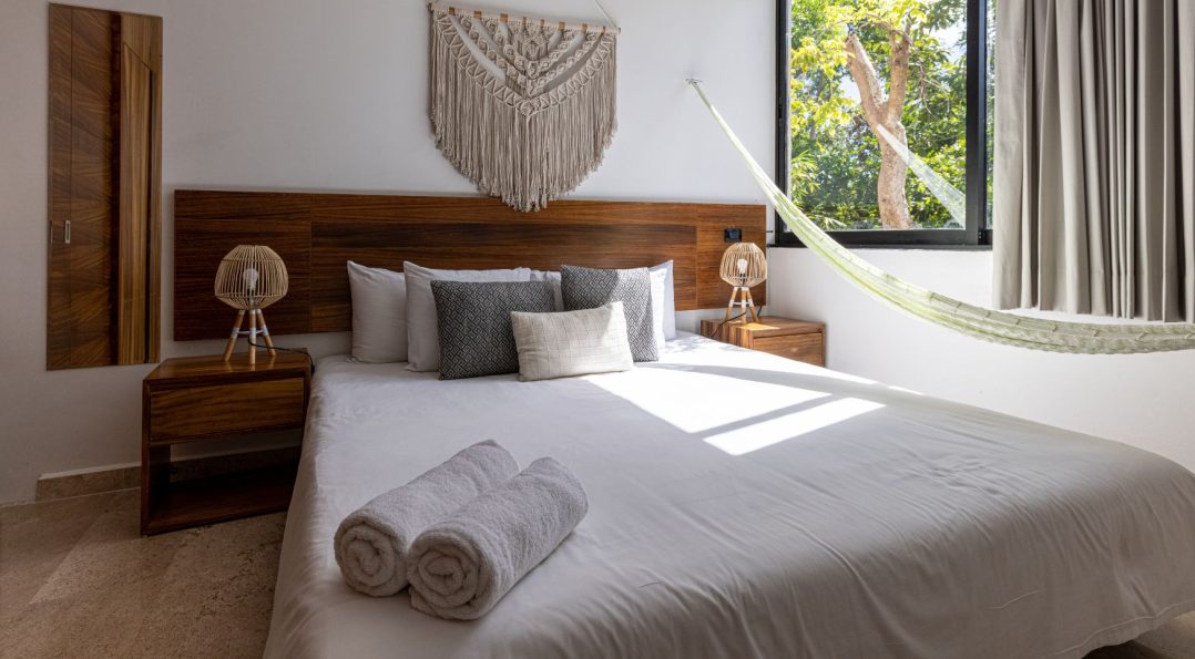 Stylish room with white, gray, and brown tones, wooden accents, a hammock, and plenty of natural light