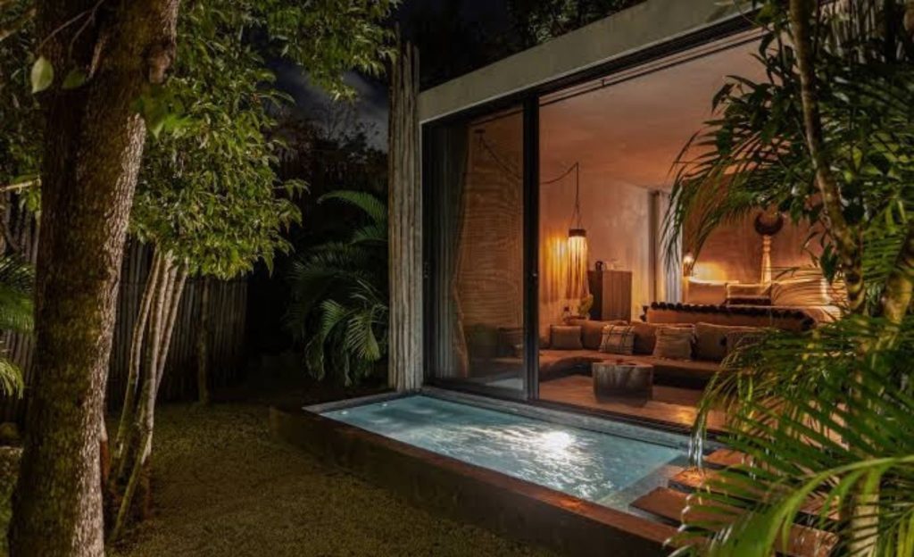 Cozy room with a private outdoor pool surrounded by lush greenery.
