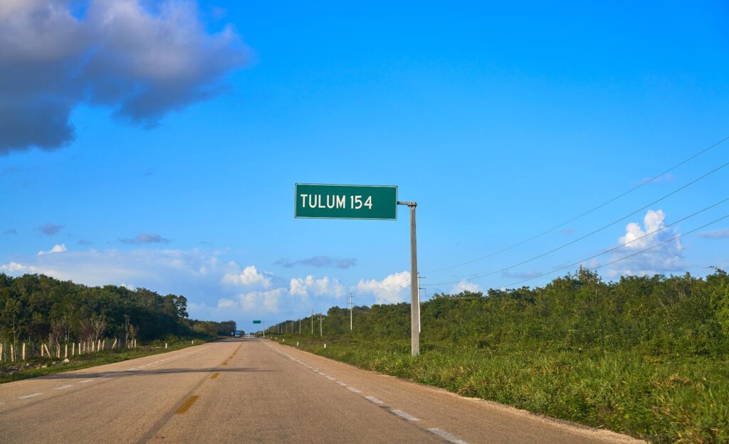 Highway to Tulum with tropical vegetation and clear skies in the background