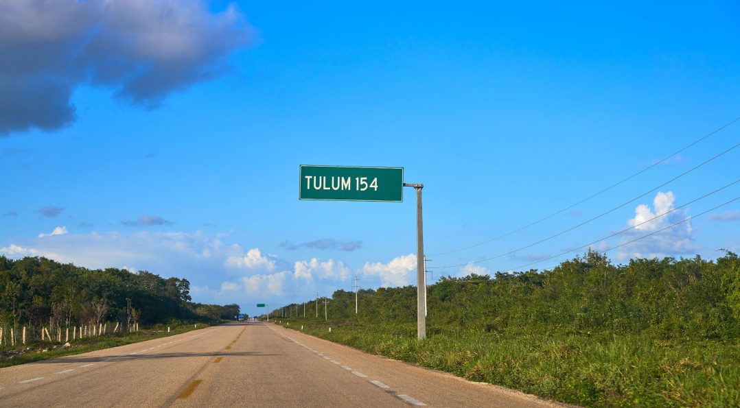 Highway to Tulum with tropical vegetation and clear skies in the background