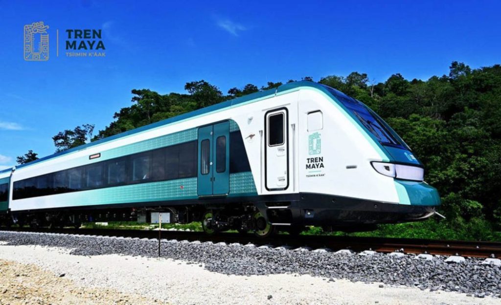 The Maya Train traveling through lush green landscapes in Mexico.
