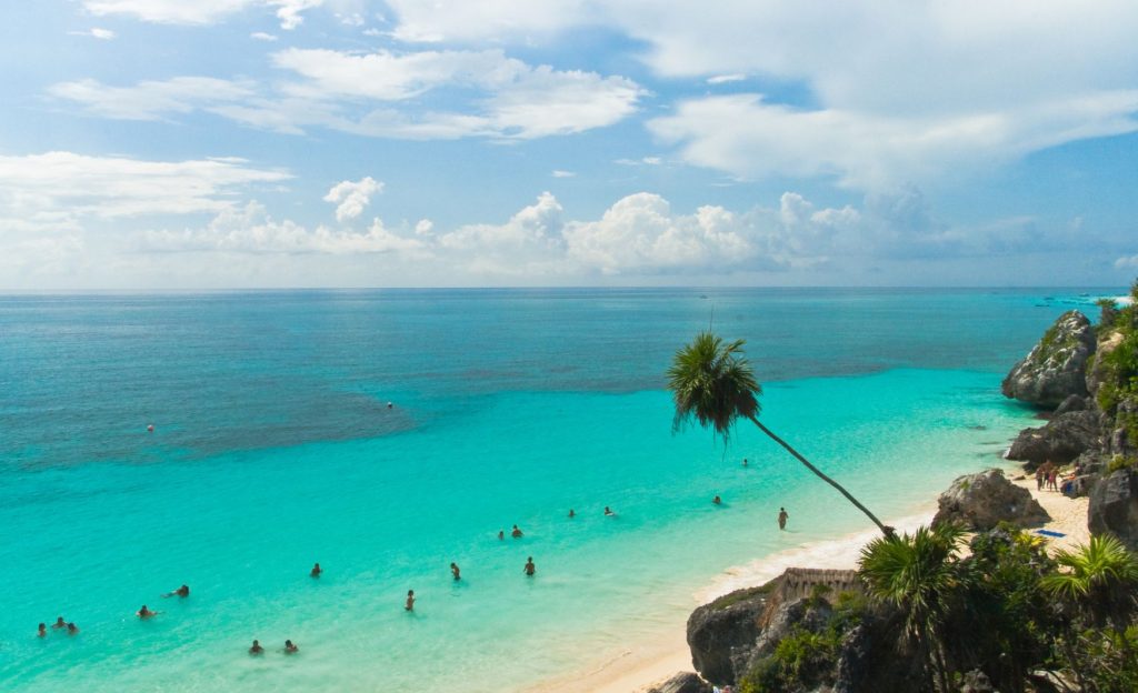Playa Paraíso in Tulum, showcasing turquoise waters, pristine white sand, and vibrant green vegetation. 