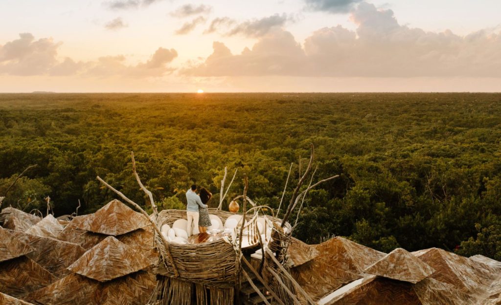 A couple enjoying a panoramic view of the lush jungle from Kin Toh in Tulum, combining relaxation with stunning natural scenery. Ideal for those seeking unique experiences in What to do in Tulum for a Day.