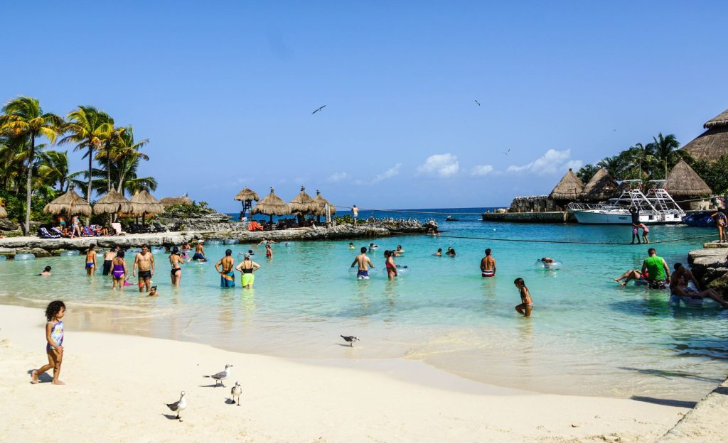 A serene family-friendly beach in Cancun, Mexico, featuring soft white sand, calm turquoise waters, and children playing in the sunshine.