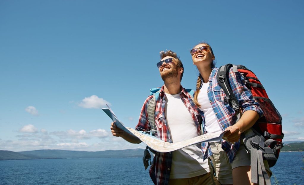 A traveling couple exploring together, with backpacks and smiles, capturing the spirit of adventure in a picturesque location.