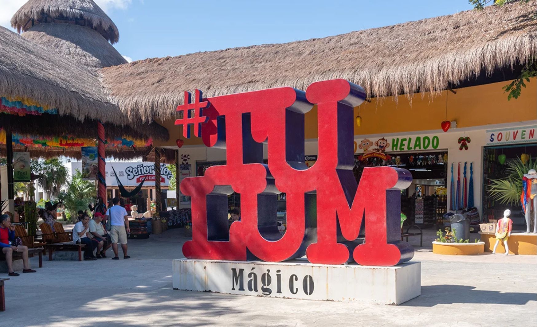 Colorful view of Tulum Centro with a large sign displaying the word "Tulum" in vibrant letters, surrounded by tourists.