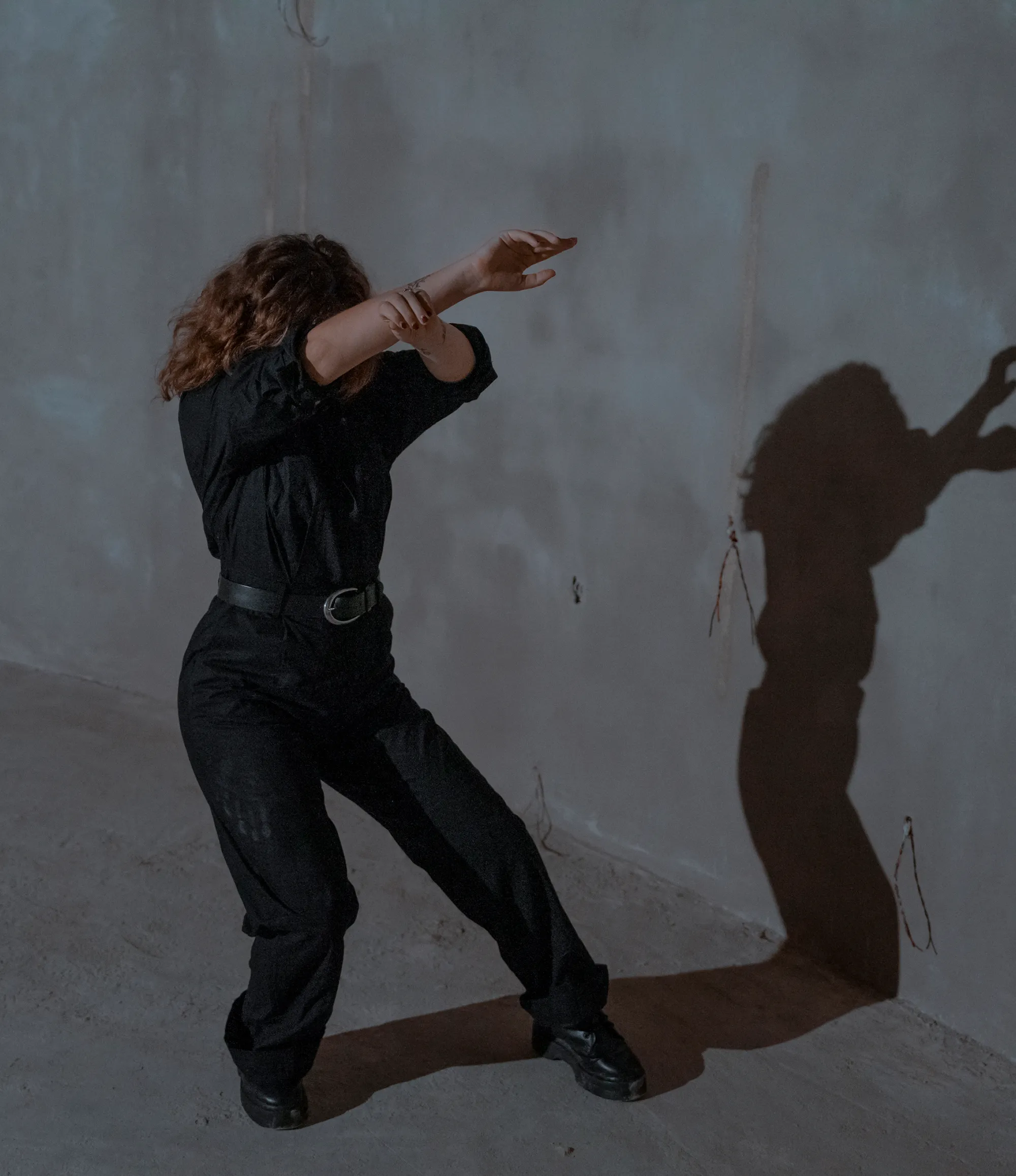 Mujer vestida de negro practicando una técnica de yoga en Tulum