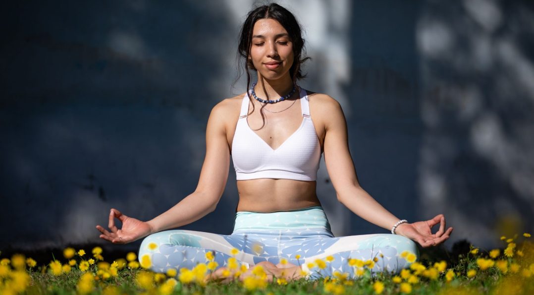 Mujer tomando clases de yoga al aire libre en Tulum