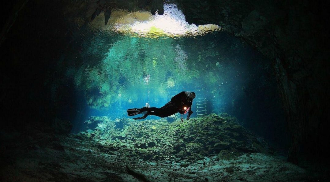 Buzo nadando en el Gran Cenote de Tulum